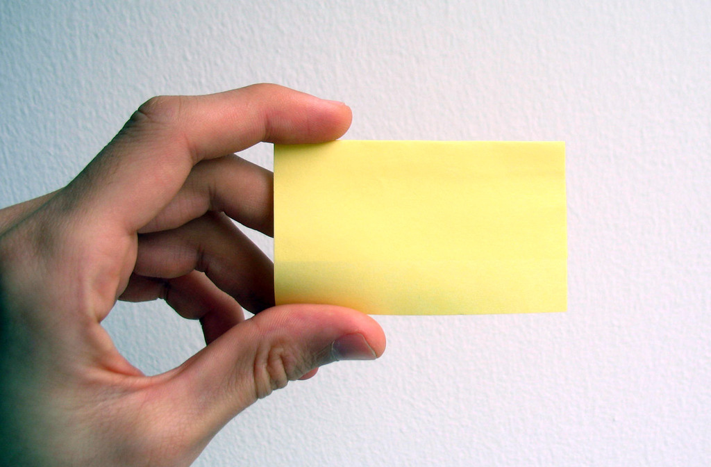 Empty business card, hand, yellow powerpoint background